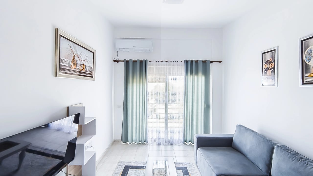 The living room of apartment 35 at Emigres Apartments, looking towards the balcony doors