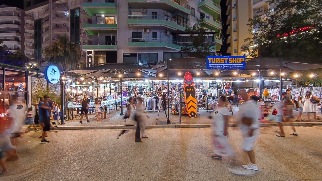 The Turist Shop on the Lungomare promenade at night, lit and open onto the street
