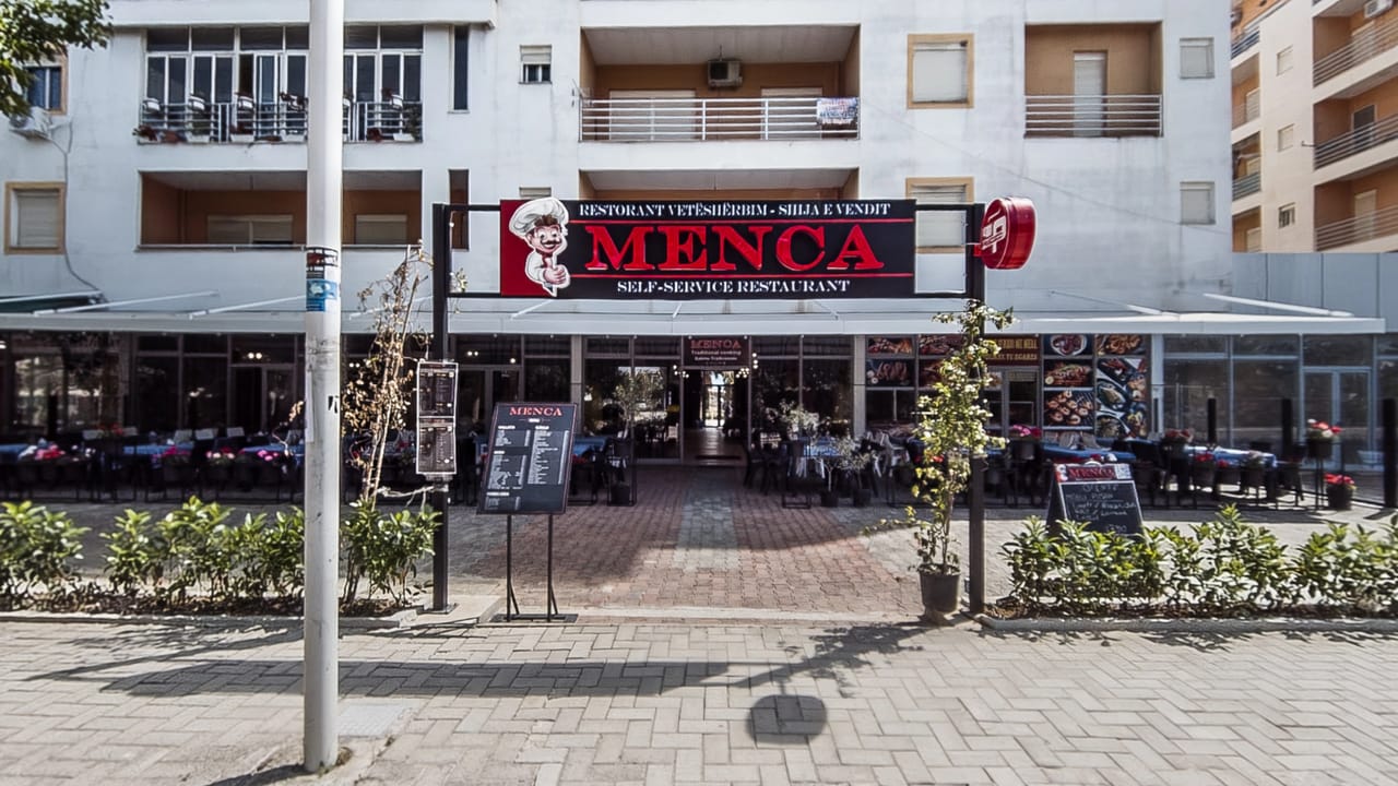 The street frontage of Restorant Menca with its sign above the terrace
